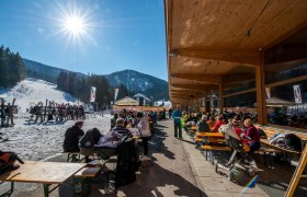 People sitting outside a restaurant in a ski resort.